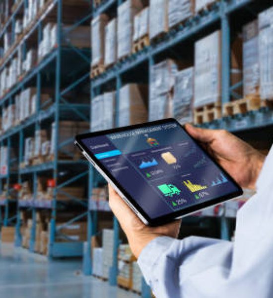 Manager using digital tablet,showing warehouse software management dashboard on blurred warehouse as background